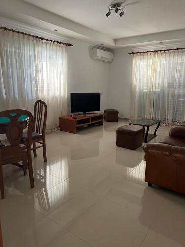 a living room with a tv and a couch and a table at Alojamento dos Redondos in Fernao Ferro