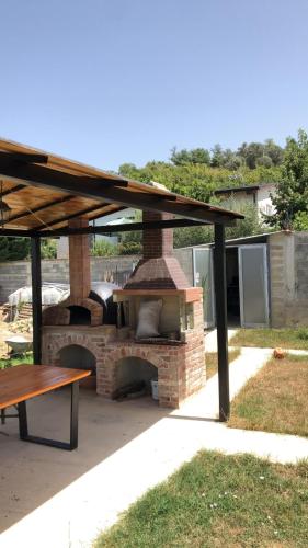 um forno de tijolo com uma mesa de madeira e uma mesa de piquenique em RX villa em Kashari