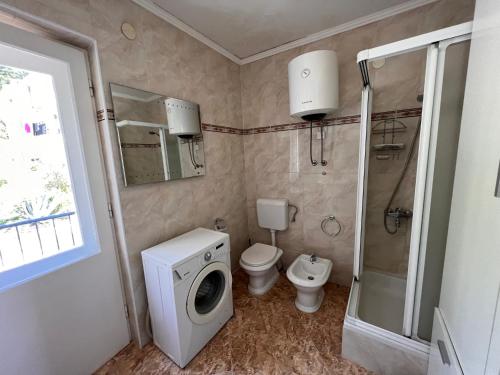a bathroom with a washing machine and a toilet at Adriatic View in Split