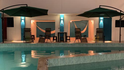 a swimming pool with chairs and umbrellas next to a pool at Hotel Las Brisas in Catemaco