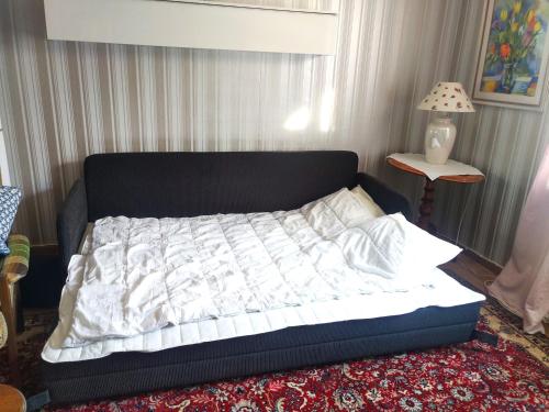 a bed with a black and white comforter in a room at Hus Näckrosen in Ruda