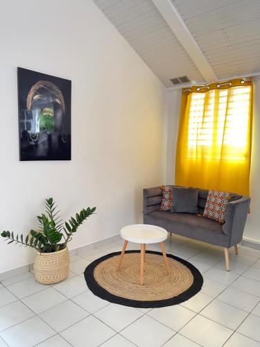 een woonkamer met een bank en een tafel bij STUDIO VUE ROCHER DU DIAMANT in Le Marin