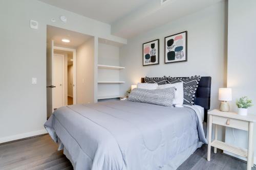 a bedroom with a large bed in a white room at Stylish Condo at Clarendon with Rooftop Views in Arlington