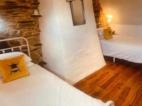Habitación pequeña con 2 camas en un edificio en Trevejean chambre d'hotes de charme, en Guerlédan