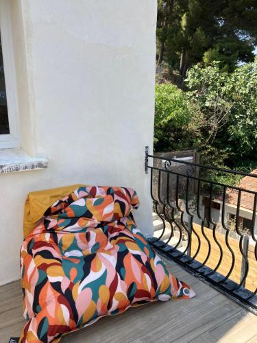 a bed with a colorful comforter on a balcony at Appartement T4 terrasse et vue in Istres