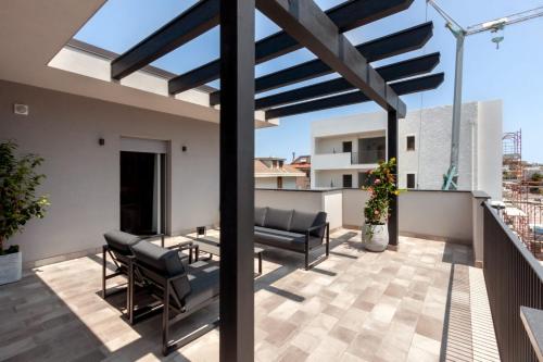 a patio with chairs and a table on a roof at La Sentina Experience in San Benedetto del Tronto