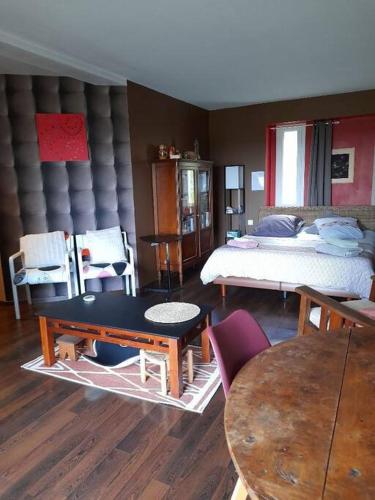 une chambre avec un lit, une table et des chaises dans l'établissement Gite de la Piegerie, à Courgenard