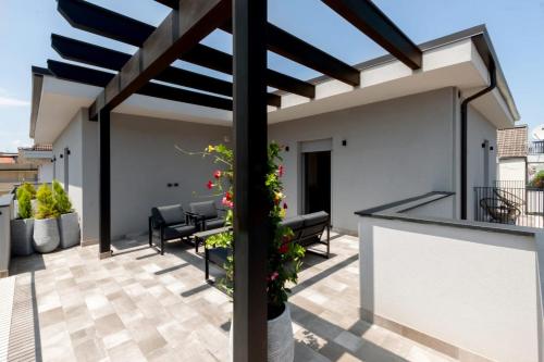 a patio with a pergola and patio furniture on a roof at La Sentina Experience in San Benedetto del Tronto