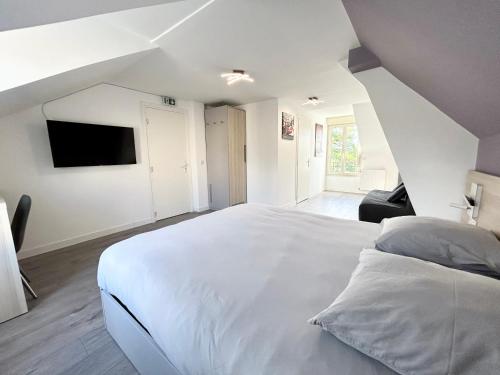 a bedroom with a large white bed and a tv at 12.Studio#Creteil#Loft#Cinéma#Exclusif in Créteil