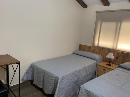 a small bedroom with two beds and a table at La Andana in Macastre