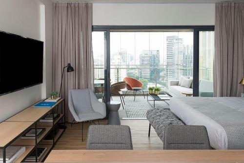 um quarto de hotel com uma cama e uma sala de estar em Forma Itaim em São Paulo