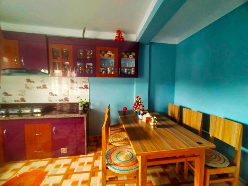a kitchen with a wooden table and a blue wall at Peace Homestay in Kathmandu