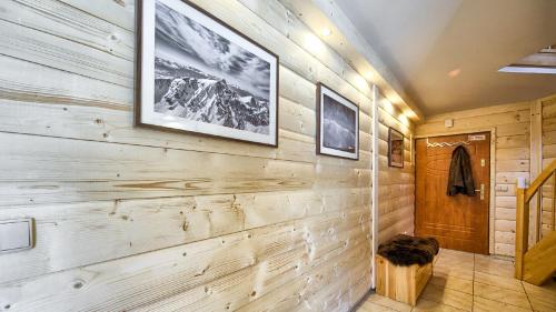 łazienka z drewnianą ścianą z dwoma obrazami w obiekcie VisitZakopane - Giewont View Apartment w mieście Kościelisko