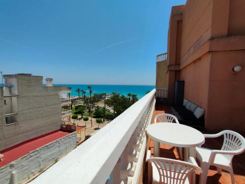 a balcony with a table and chairs and the ocean at Playa Paradís - Primera linea de playa - AP-7 3min - Self check-in 24h in Moncófar