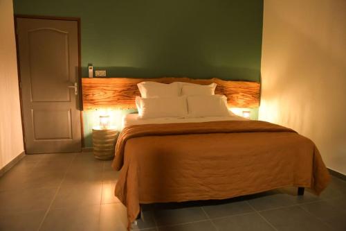 Un pat sau paturi într-o cameră la La Palmeraie Lodge Terrasse & Piscine et Jacuzzi