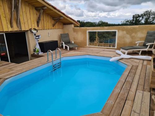 une piscine avec une terrasse en bois et une visière de piscine dans l'établissement Corps de Ferme Labarthe à Pimbo, à Pimbo