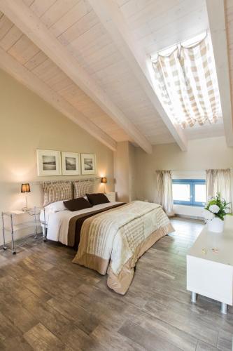 a bedroom with a large bed and a skylight at Cascina Arcangelo Raffaele in Verduno