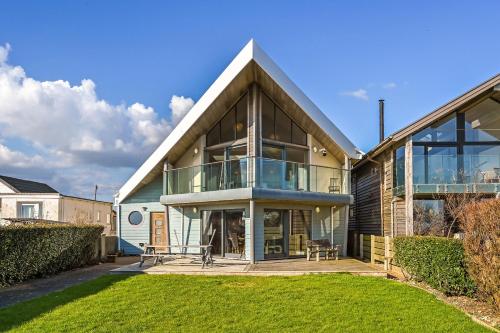 a large house with a large glass facade at Le Var - Beachfront home in Bracklesham Bay in Chichester