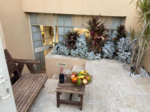 a bowl of fruit and a bottle of wine on a table at Studio near the sea in Netanya