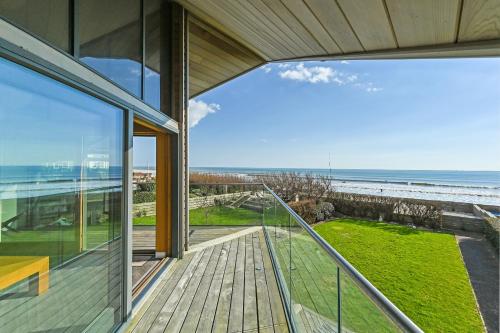 a house with a balcony with a view of the ocean at Le Var - Beachfront home in Bracklesham Bay in Chichester