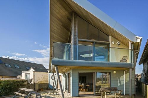 a house with large glass windows on the side of it at Le Var - Beachfront home in Bracklesham Bay in Chichester