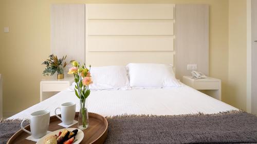 阿依納帕的住宿－Tasia Maris Beach Hotel - Adults Only，一张带花瓶桌子的白色床