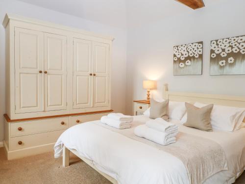 a bedroom with a white bed and a white cabinet at Squirrels Drey in Fareham