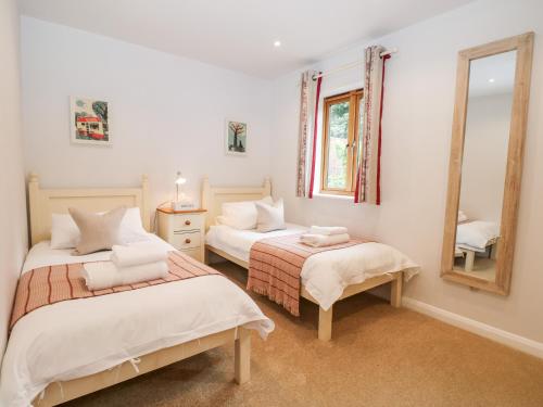 a bedroom with two beds and a mirror at Squirrels Drey in Fareham