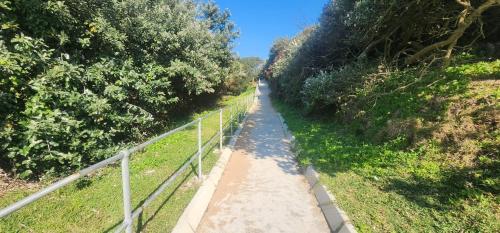 a dirt path with a fence and trees at Hello Holiday at 4 Boboyi Mangrove Beach Estate in Port Shepstone