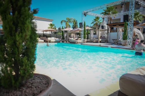 - une piscine dans un complexe avec des personnes dans l'eau dans l'établissement Porticcio Vacations - Terrasse, Piscine, Jacuzzi, Clim - by TGB, à Porticcio
