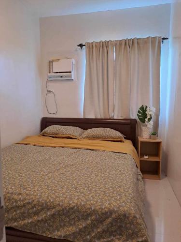 ein Schlafzimmer mit einem Bett und einem Fenster mit einem Vorhang in der Unterkunft Camella Manor Majorca in Bacolod City