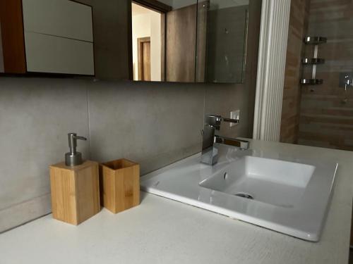 een badkamer met een witte wastafel en een spiegel bij Il rifugio dei Doria in Dolceacqua