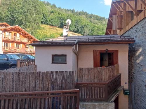 une maison avec une clôture en bois à côté d'un parking dans l'établissement Maison Ste Foy Tarentaise, à Sainte-Foy-Tarentaise