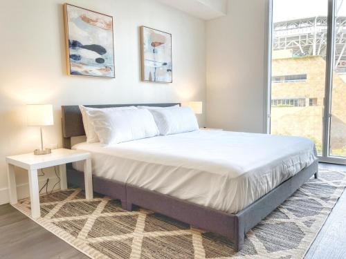 a bedroom with a bed and a table and a window at Stunning Apartment By Petco Park! in San Diego