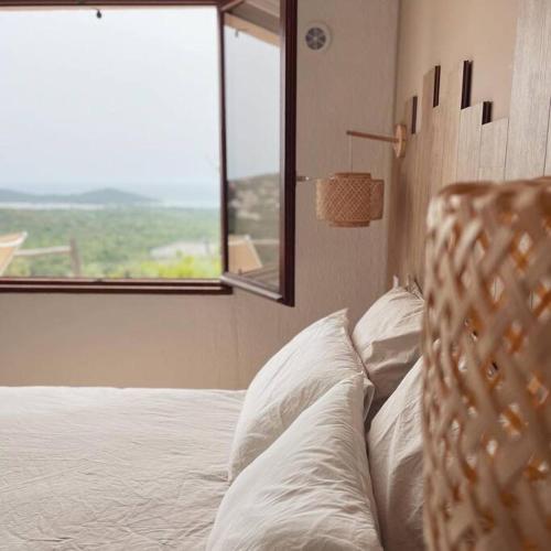 une chambre avec un lit avec des oreillers blancs et une fenêtre dans l'établissement CASA ANPÀ - Appartement Vue Mer, à Zonza