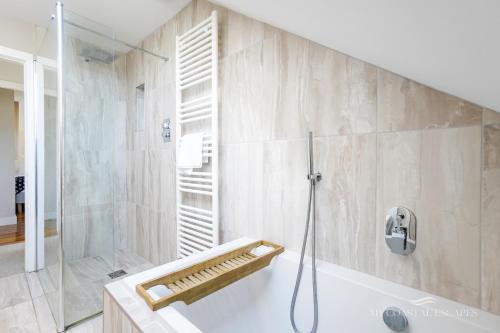 a bathroom with a shower and a bath tub at Duneside House in Beadnell