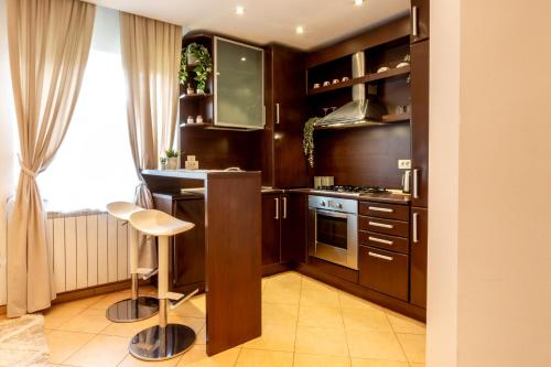 a kitchen with wooden cabinets and a stove top oven at 1BR Apt with Jacuzzi near Herastrau: Ideal Getaway in Bucharest