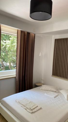 sypialnia z białym łóżkiem i oknem w obiekcie Emerald Suites w mieście Vryses