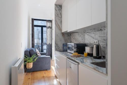 a kitchen with white cabinets and a counter top at Luxury Design Apartment - Premium Location in Porto