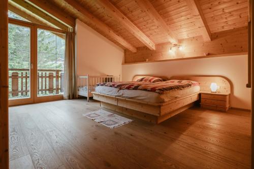 ein Schlafzimmer mit einem Bett und einem großen Fenster in der Unterkunft Ferien und Familienhaus Robert Haider in Innervillgraten