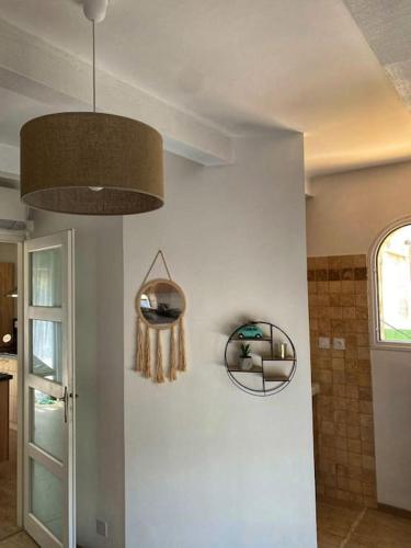 une pièce avec un mur blanc avec un miroir et une lumière dans l'établissement Marigny Appartement, à Villeneuve-lès-Maguelone