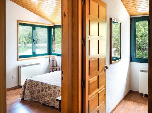 a room with a bedroom with a bed and windows at Casa rural fuente de la mora in Uña