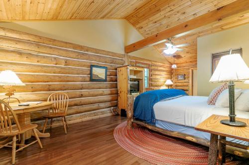 una camera da letto in stile baita di tronchi con letto e tavolo di Dancing Bear Lodge a Townsend