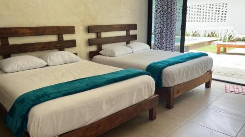 two beds sitting in a room with at King's Tuuch Bacalar - Cerca de la Laguna in Bacalar