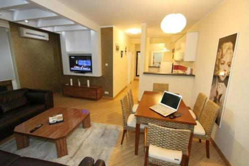 a living room with a couch and a table with a laptop at Vip apartment Beograd in Belgrade