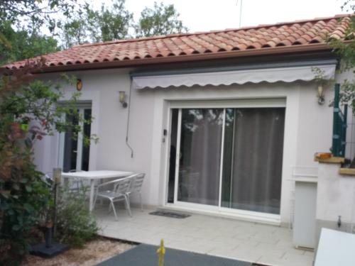 une maison avec une porte coulissante en verre et une table dans l'établissement Gîte du pech, à Arcambal