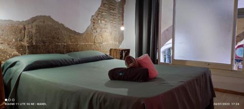 Una cama con una almohada roja encima. en La Impronta Relax en Lleida