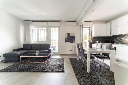 sala de estar con sofá y mesa en Oasis Luxury - A.C/Terrace/2Bedrooms, en Bérgamo