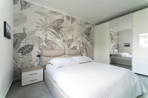 sypialnia z białym łóżkiem i malowidłem ściennym w obiekcie Oasis Luxury - A.C/Terrace/2Bedrooms w Bergamo
