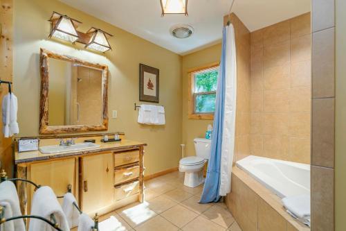 a bathroom with a tub and a toilet and a sink at Dancing Bear Lodge in Townsend
